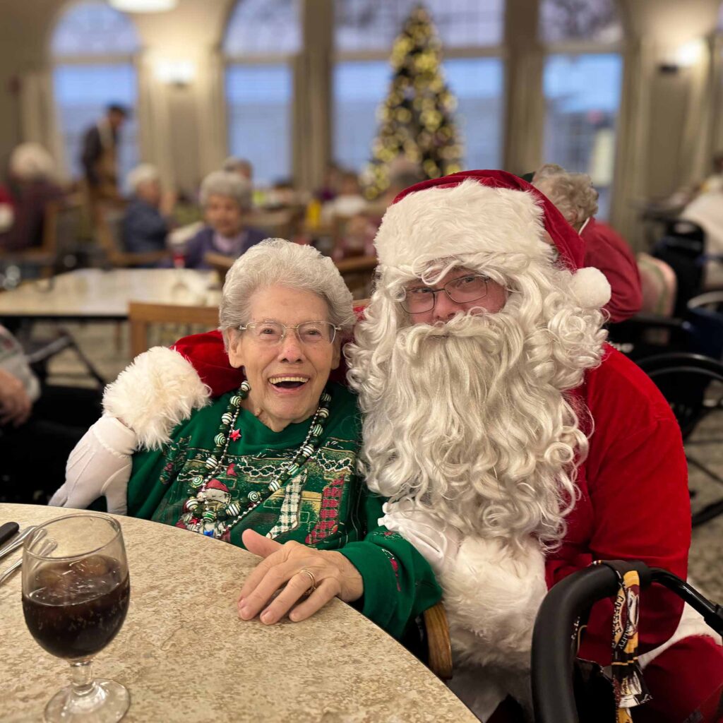 Santa Claus smiling with a bright and joyful senior woman.