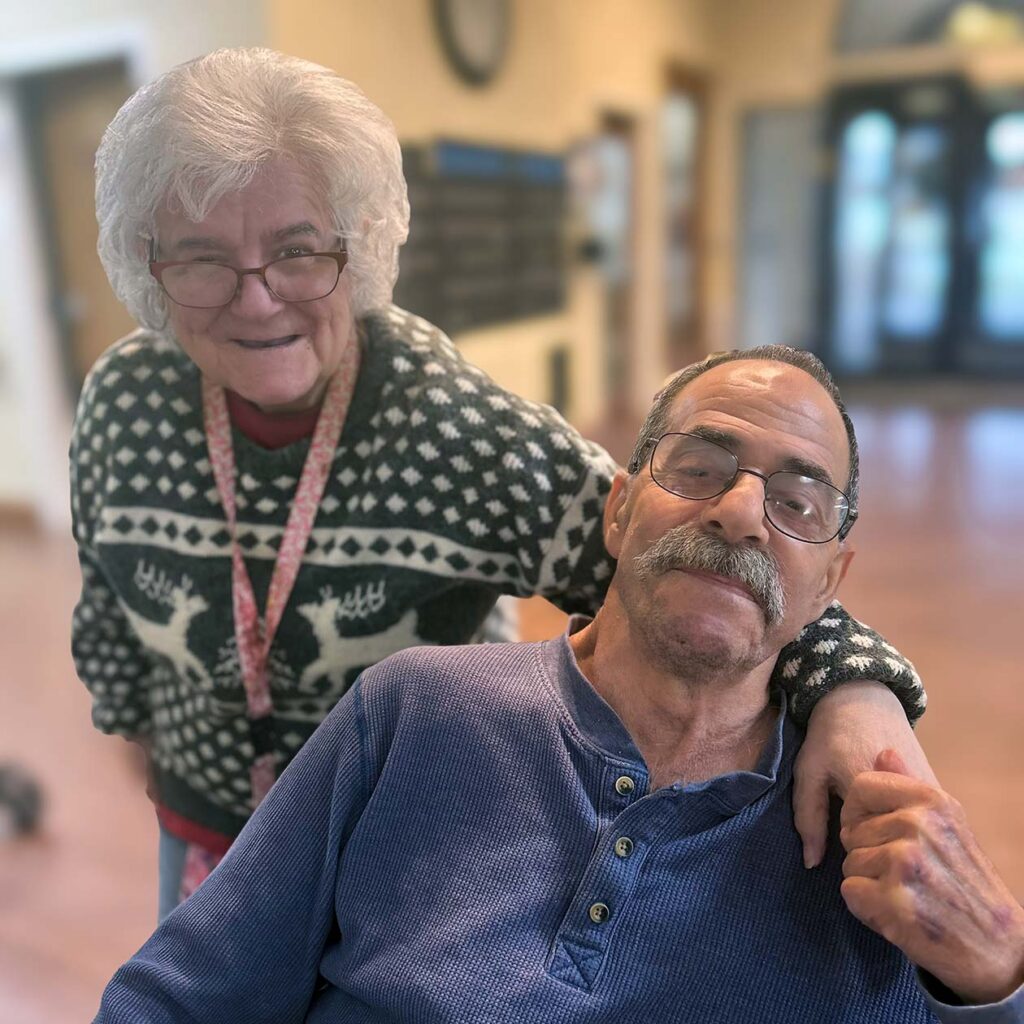 A man and woman smile with warmth and camaraderie at Cedar Trails Senior Living.