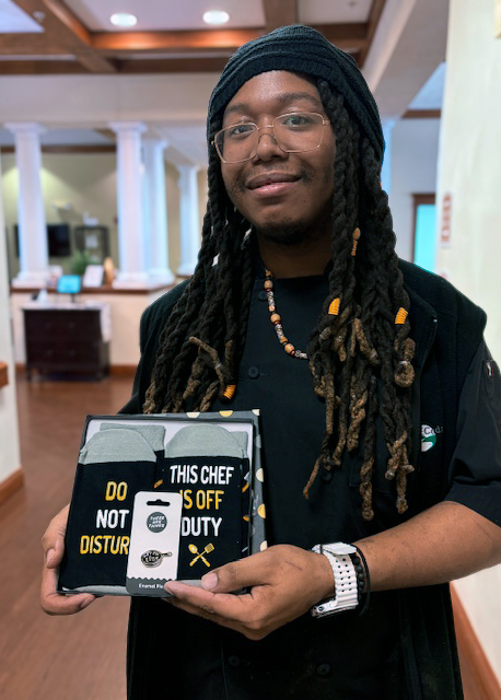 A chef at Cedar Trails Senior Living smiles proudly, displaying a gift given in gratitude.